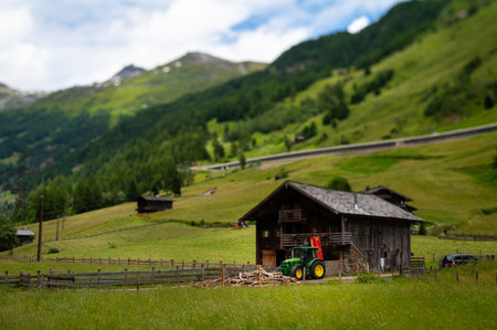 Old small wooden house and green tractor in the alps, sunny day in summer, East Tyrol (Austria)のeditorial素材