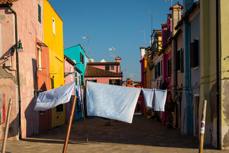 Burano, Italy - October 25, 2021: Colorful houses in Burano on a sunny morning in late autumn, laundry hanging for dryingのeditorial素材