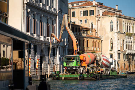 Venice, Italy - October 29, 2021: Construction work with a concrete mixer on a boat on the canale grande in Venice (Italy), sunny day in winterのeditorial素材