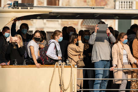 Venice, Italy - October 28, 2021: Vaporetto full of people wearing face masks in Venice (Italy) on a...