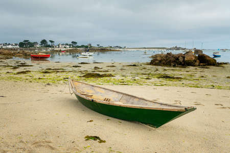 Lanilis, France - August 10, 2020: Old small boat lying on the beach, low tide, sunny day in summerのeditorial素材