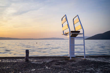 White ladder of a diving board at the beach in Cres (Croatia), sunset in springtimeの写真素材