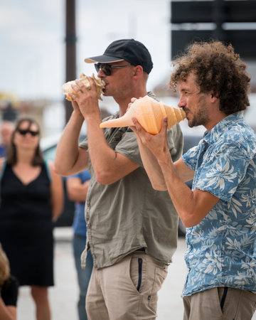 Saint Malo, France - August 11, 2018: Street musicians performing on conches, cloudy day in summerのeditorial素材