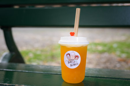 Bruges, Belgium - July 4, 2022: A bubble tea cup on a bench, daylight, drink, summerのeditorial素材