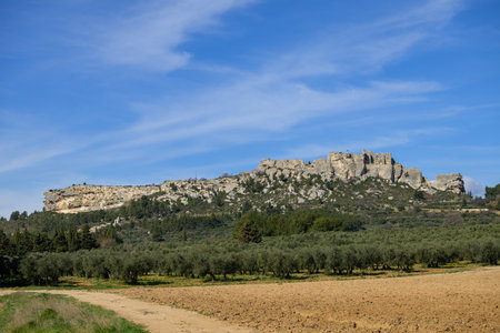 The massive rock of Les Baux de Provence (France) on a clear sunny day in springtime with blue skyの写真素材