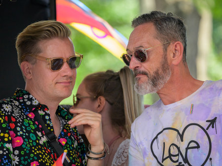 Vienna, Austria - June 17, 2023: People at Vienna Pride in summer on Wiener Ringstrasse, two men talkingのeditorial素材