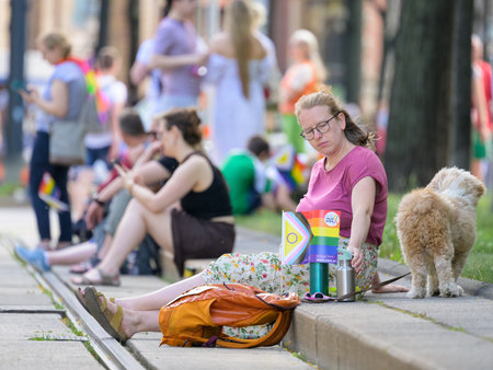 Vienna, Austria - June 17, 2023: People at Vienna Pride in summer on Wiener Ringstrasse, woman sitting on the groundのeditorial素材
