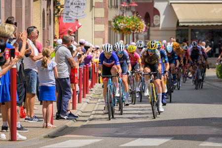 Muster, France - July 30, 2022: Athletes and escorts of the Tour de France Femmes passing through the city, group of athletesのeditorial素材
