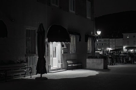 Cres, Croatia - October 24, 2022: Narrow street of Cres in the night, entrance to a house, black and whiteのeditorial素材