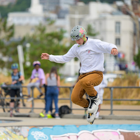 Le Havre, France - July 23, 2022: Young people practicing at a skater park on a cloudy day in summer, boy jumping with inline skatersのeditorial素材