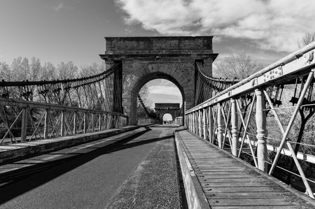 Arles, France - March 12, 2023: Pont De Fourques suspension bridge on a sunny day in springtime, black and whiteのeditorial素材