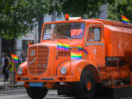 Vienna, Austria - June 08, 2024: People at Vienna Pride in summer on Wiener Ringstrasse, orange cleaning vehicle cleaning the street after the paradeのeditorial素材