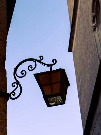 An old vintage lamp hanging from a house at broad daylightの写真素材