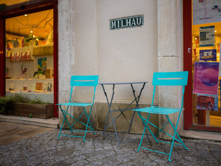 Arles, France - March 7, 2023: Colorful Chairs and tables of a bar on the street, rainy day in springtimeのeditorial素材