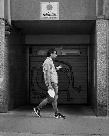 Vienna, Austria - August 26, 2022: A man walking alone through the streets of Vienna on a sunny dayのeditorial素材