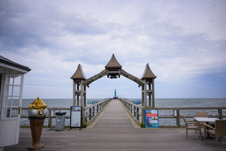 Sellin, Germany - July 12, 2024: A wooden step leading into the sea on a cloudy day