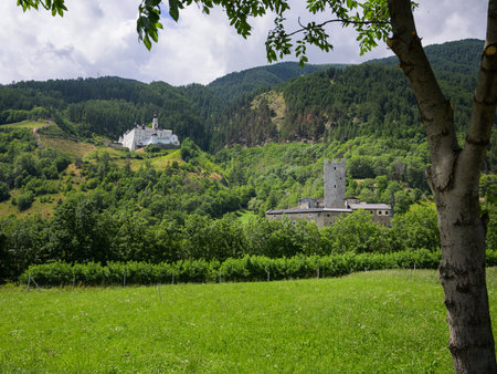 Burgeis, Italy - July 6, 2023: Abbey of Monte Maria and Castello del Principe on a sunny day in summer, green meadowのeditorial素材