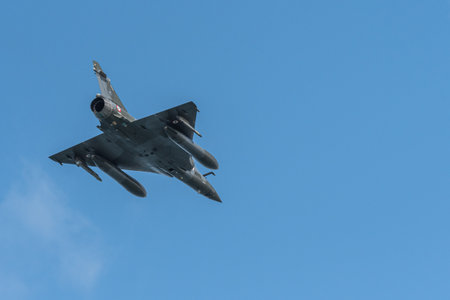 Saint-Coulomb, France - August 9, 2018: Fighter jet flying low viewed from below against clear blue skyのeditorial素材