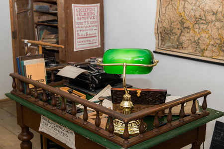 Niedersulz, Austria - May 27, 2018: A small vintage desk with banker lamp and typewriter is displayed indoors at a museum showing historic objects.のeditorial素材