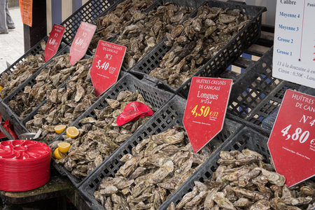 Cancale, France - August 13, 2018: A street stall displays oysters with price signs in Cancale France on a cloudy summer day.のeditorial素材