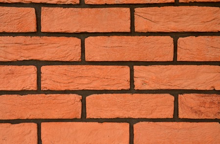 Rough red brick texture with black joints