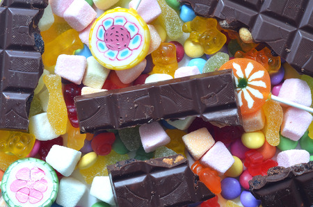 Candy, lollipop, chocolate, colored smarties and gummy bears background