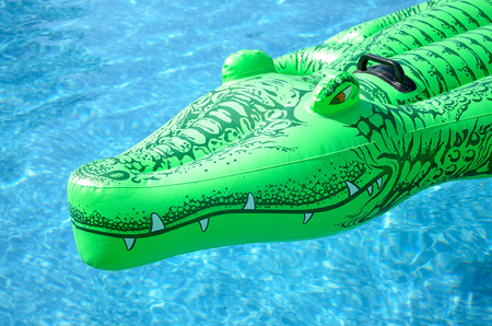 Inflatable deck chair in the shape of a crocodile in the poolの写真素材