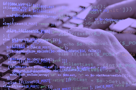 Close-up of typing male hands on computer keyboard and programming code collage stylized in purple...