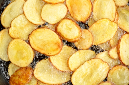Close-up of fried potatoes in oilの写真素材