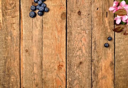 Blueberries and spring flowers on wooden table backgroundの写真素材