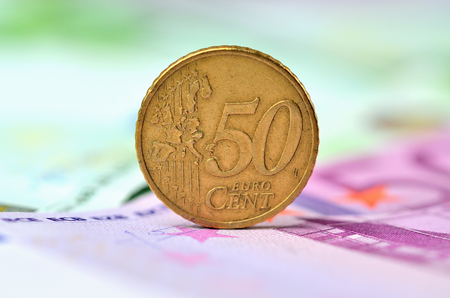 50 cent coins standing on the edge on euro banknotesの写真素材