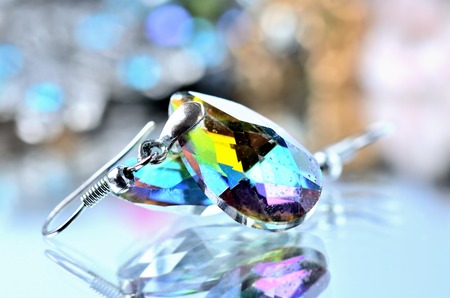 Close-up of green-blue drops shaped earrings with reflection effect - colored backgrounds - blueの写真素材