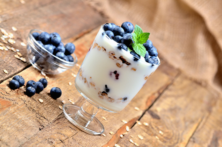 Greek yoghurt with oatmeal, fresh blueberries and mint leavesの写真素材