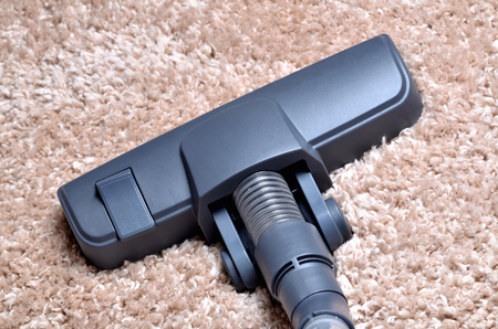 Head of vacuum cleaner on shaggy carpet - close-up of noozleの写真素材