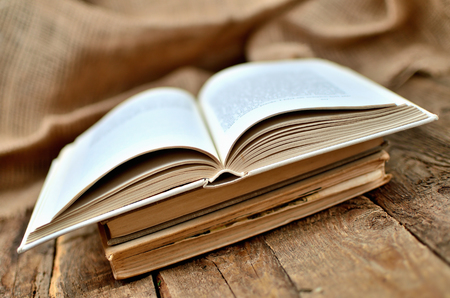 Old, vintage shabby half open book on rustic wooden tableの写真素材