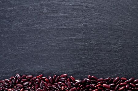 Heap of kidney beans at the bottom on slate slab. Top view frame with copyspace.の写真素材