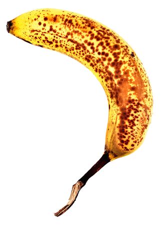 Overripe banana with brown spots isolated on white background.の写真素材
