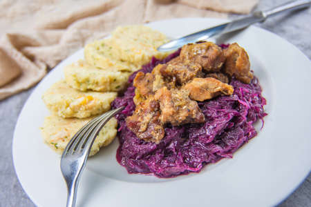 Roast pork with dumplings and sauerkraut. Typical Czech national meal with homemade bread dumplings red cabbage on concrete texture background.の写真素材