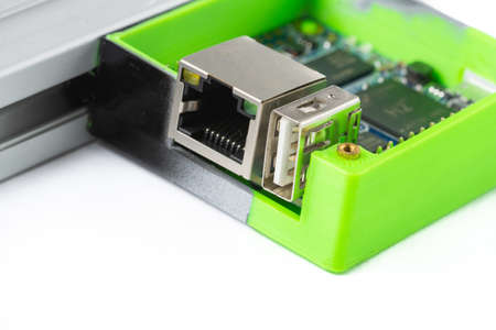 Close-up of orange pi in printed box on 3d printer isolated on white background.