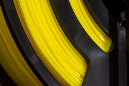 Yellow filament of plastic for printing on 3D printer. Spools of 3D printing motley thermoplastic...