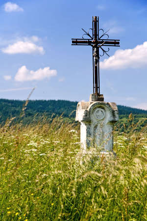 Poland, Bieszczady, Bystre. Old wayside cross on the meadow.の写真素材