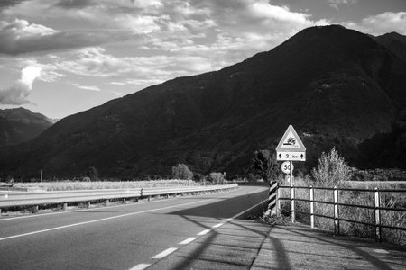Road sign on the road in the mountains. Black and white photo.