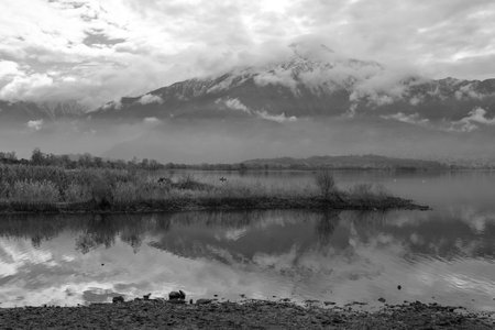 Black and white landscape image of a lake with mountains in the background