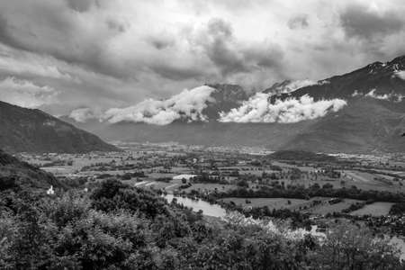 Black and white photo of the mountains and the river in the valleyの写真素材