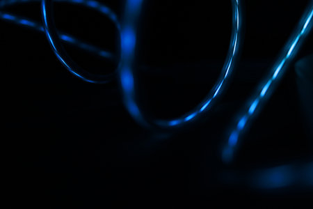 Blue light reflected in the surface of glossy swirling wires.の写真素材