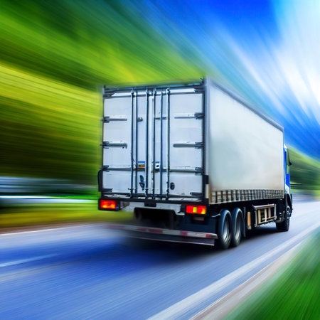 Truck with cargo driving on the road with green nature and blue sky motion blur background.の素材