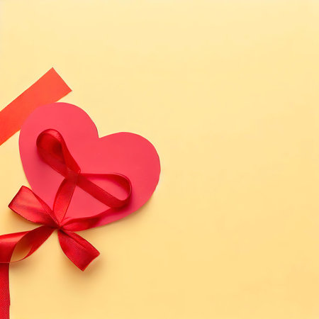 Paper red heart and ribbon with a bow on a yellow background, flat lay. Banner, copy space. Gift background with place for textの素材