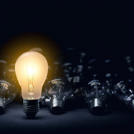 One of Lightbulb glowing among shutdown light bulb in dark area with copy space for creative thinking , problem solving solution and outstanding conceptの素材