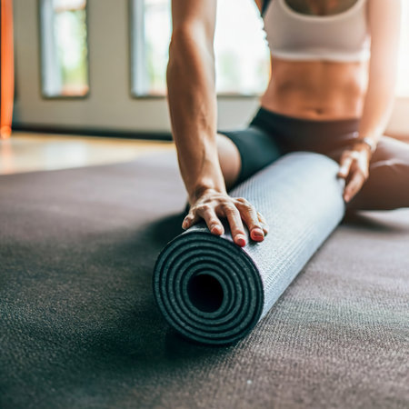 Exercise mat rolling keeping after yoga class. Workout and sport training concept. Hands on carpetの素材