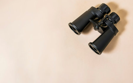 Binoculars black on a beige backgroundの素材